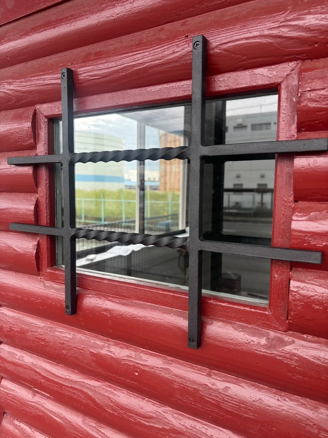 「ログハウス玄関ドアに命を吹き込むロートアイアン装飾」